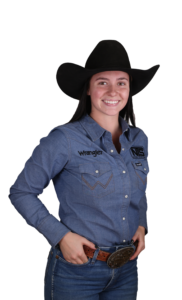 Young woman in Western attire with cowboy hat and denim, exuding confident cowgirl spirit.