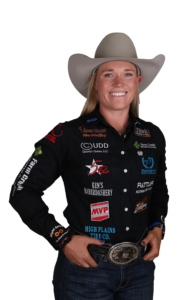 Rodeo star Taylor Munsell in sponsor-laden attire with a white cowboy hat and belt buckle.